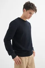 Sweater de punto color naranja claro jaspeado, con cuello redondo y mangas largas.