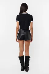 Remera corta negra de algodón tipo baby tee, con mangas cortas y detalles en blanco en cuello y mangas. Estampa frontal con la leyenda "Rocking Slaying" en blanco.