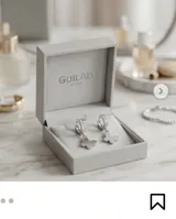 Aros tipo argolla de acero con incrustaciones de circonias y dije colgante en forma de mariposa.