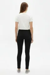 Pantalón jean skinny de tiro medio, color negro, de corte ajustado al cuerpo.