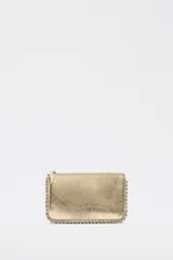 Cartera pequeña color dorado metálico con cierre superior. Presenta tachas plateadas decorativas a lo largo de los bordes superior e inferior.