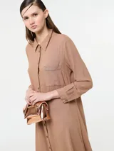 Vestido camisero largo color rojo, confeccionado en lino y viscosa, con cartera de botones delanteros centrales y bolsillo delantero superior con terminación de galón metalizado.