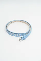 Cinturón fino de cuero sintético color celeste, con perforaciones metálicas a lo largo de toda la tira y hebilla metálica plateada.