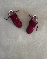 Zapatillas urbanas de cuero vacuno color negro, con suela alta y cordones.