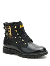 Bota de cuero negro con diseño robusto, cordones frontales y cierre lateral. Presenta detalles de tachuelas metálicas doradas, dos hebillas laterales decorativas y el logo de la marca en amarillo en la lengüeta y grabado en el talón. Cuenta con suela de goma dentada para mayor tracción.