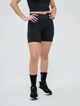 Biker deportiva Umbro para mujer, de color negro, confeccionada con tejido elástico y pretina cruzada con elástico personalizado de la marca.