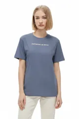 Remera de algodón de manga corta y cuello redondo, con corte holgado y estampado frontal con la frase "NOTHING IS REAL".