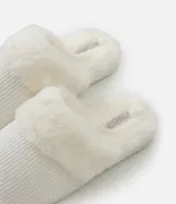 Pantufla abierta de mujer con textura acanalada y detalle de borde en peluche sintético. Cuenta con suela de goma termoplástica.