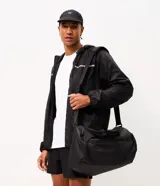 Bolso deportivo cilíndrico de poliéster color negro, con amplio espacio interior, cierre superior con cremallera, asas de mano reforzadas, asa transversal regulable y desmontable, bolsillo frontal con cremallera y bolsillo lateral de malla.