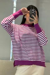 Buzo de tejido de punto con diseño de rayas horizontales en color fucsia y blanco, cuello redondo, mangas largas con puños anchos y ruedo con abertura lateral.