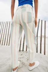 Pantalón jeans de corte tapered y tiro medio, con diseño de rayas verticales en tonos blanco, verde menta y naranja.