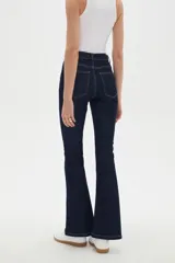 Pantalón jean de corte oxford, tiro alto, con bolsillos y diseño de pernera ajustada en muslos y acampanada desde las rodillas.