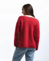 Buzo de lana merino con cuello bote y mangas largas. Presenta un detalle bordado a mano en color azul en la parte inferior.