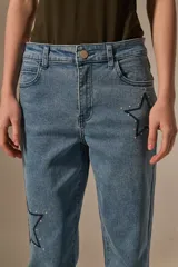 Pantalon de jean azul de corte recto y calce medio, con bordados de estrellas y detalles de pequeñas tachas.