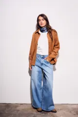 Camisa color marrón de gamuza sintética, de corte recto, con cuello clásico, cierre frontal con botones y mangas largas.