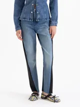 Pantalón de jean con diseño bicolor, presentando el frente en denim azul lavado con efecto vintage y los laterales y parte trasera en tejido engomado negro. Posee silueta recta tipo mom fit y tiro medio.