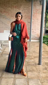 Top de fiesta color verde azulado iridiscente, con escote halter y frunces drapeados en el frente. Presenta un vivo de color naranja rojizo en el borde del escote y tiras para anudar en la espalda.