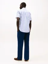 Camisa de manga corta Tommy Hilfiger, corte regular, confeccionada en popelín de algodón con tecnología Flex. Diseño a rayas verticales blancas y azules.