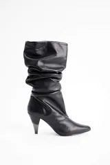 Bota de caña media en cuero negro con diseño slouchy, punta fina y taco cónico de altura media.