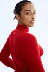 Top de punto fino color rojo, de manga larga y cuello alto.