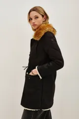 Campera negra de diseño híbrido con cuerpo acolchado en forma de rombos y mangas de textura lisa. Presenta un cuello de piel sintética desmontable en tono marrón y detalles de corderito en los puños y el ruedo. Incluye cierre frontal y cordones ajustables en la cintura.