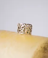 Anillo ancho de plata con diseño de agujeros irregulares.