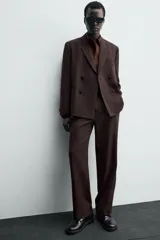 Pantalón de traje straight fit color marrón oscuro, confeccionado en tejido con lana. Cuenta con bolsillos frontales, bolsillos traseros de vivo y cierre frontal con cremallera y gancho metálico oculto.