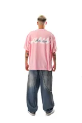 Remera de algodón peinado color rosa, de corte holgado y manga corta, con un pequeño bordado en el pecho.