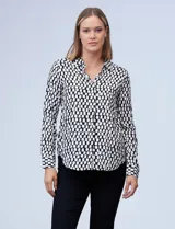 Camisa estampada blanca y negra con cuello clásico, abertura frontal con botones ocultos y mangas largas con puños abotonados.