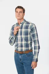 Camisa de manga larga con estampado de cuadros en tonos azules y beige. Presenta cuello clásico con botones, bolsillo frontal en el pecho con logo bordado y cierre frontal de botones.