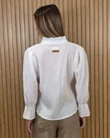 Blusa blanca de algodón con escote en V y cuello mao. Presenta mangas largas abullonadas con puños acampanados y fruncidos.
