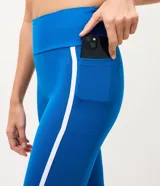 Pantalón legging deportivo Get Over de color azul, confeccionado en microfibra con cintura alta y ancha, recortes anatómicos y bies contrastante blanco a los lados.