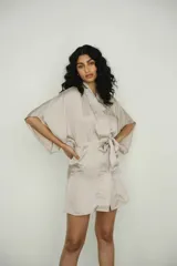 Bata color crema confeccionada en seda, con lazo de ajuste en la cintura.