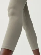 Legging capri de tejido deportivo negro, con cintura cruzada bicolor, siendo la parte superior blanca.