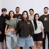 Canguro azul marino con capucha y bolsillo delantero. Estampado en el pecho con el logo de la banda La Vela Puerca en color naranja.