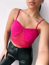 Top fucsia con copas de crepé y red en el centro.