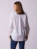 Camisa blanca de tencel, marca Grand & Greene, con cuello a la base, escote en V y abertura central con botones. Manga larga con puño y botón.