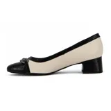 Zapato de tacón bajo Comfortflex, color blanco y negro charol, con punta redonda y detalle de moño metálico.