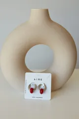 Aros de argolla en acero quirúrgico con dije de piedra natural en tono azul.