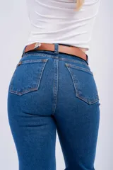 Pantalón de jean estilo Oxford de tiro alto, con ajuste en muslos y corte acampanado en la parte inferior. Presenta un lavado azul clásico y costuras reforzadas.