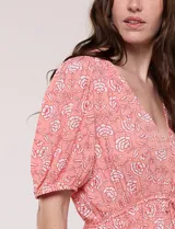 Vestido corto de calce fluido con escote en V y mangas cortas abullonadas. Presenta cintura elastizada con cordón ajustable y falda con volados en el borde inferior.