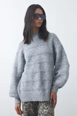 Sweater de punto con textura tramada, color azul marino, de silueta relajada y mangas abullonadas con puños ajustados.