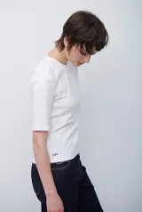 Remera básica de algodón color blanco, con cuello redondo y mangas que llegan hasta el codo.