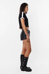 Remera negra de algodón tipo baby tee, mangas cortas con detalles en blanco en hombros y terminaciones. Estampa frontal con texto blanco.