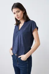 Remera de manga corta con escote en V y detalle de cartera frontal, confeccionada en tejido de punto con textura jaspeada.