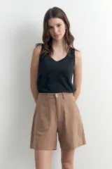 Short de vestir color camel, tiro alto, con pliegues frontales y bolsillos laterales.