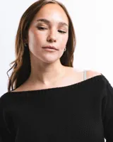 Buzo de lana merino con cuello bote y mangas largas. Presenta un detalle bordado a mano en color azul en la parte inferior.