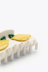 Pinza de pelo grande, tipo garra, de color blanco con dos aplicaciones de limones amarillos y hojas verdes.