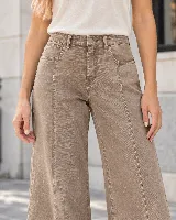 Jean de tiro alto y pierna amplia, color taupe con lavado efecto desgastado. Cuenta con costuras verticales decorativas en el frente, bolsillos delanteros y traseros, y cierre frontal con botón y cremallera.