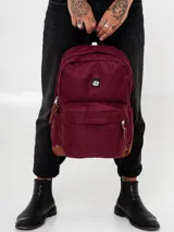 Mochila color borgoña con base de cuero sintético color marrón.